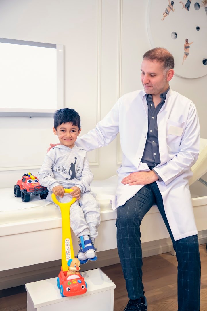 A dentist resting a hand on a young child's shoulder in a bright, calm treatment room